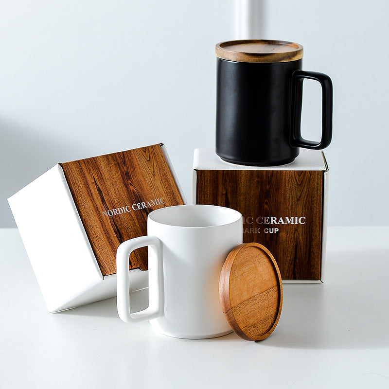 Two ceramic mugs with wooden lids on a white surface, with 'Nordic Ceramic' branding visible.