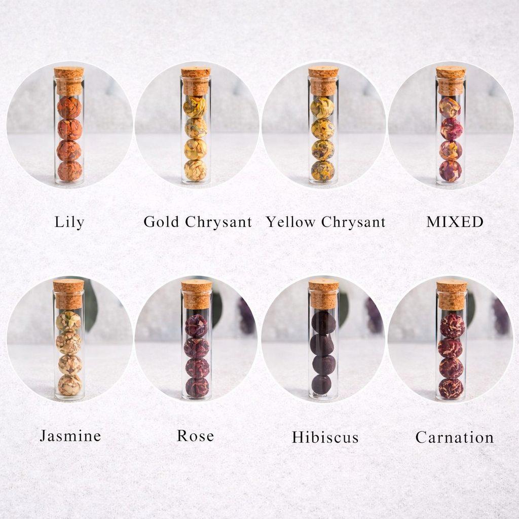 Set of glass vials with cork lids containing different types of dried flowers on a white background.
