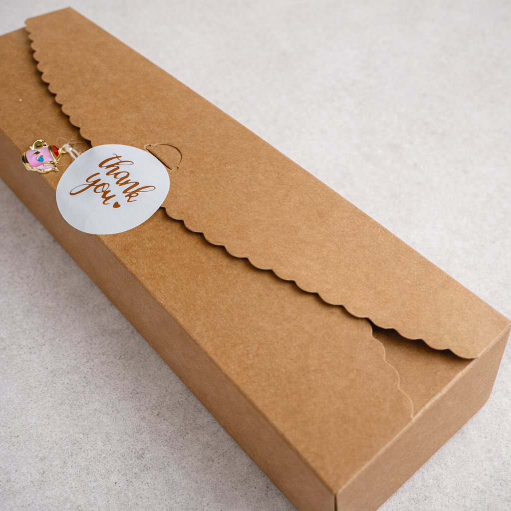 Brown paper box with a 'thank you' tag on a light gray background