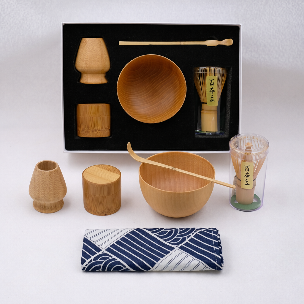 Set of wooden tea-making utensils with a black box on a white background