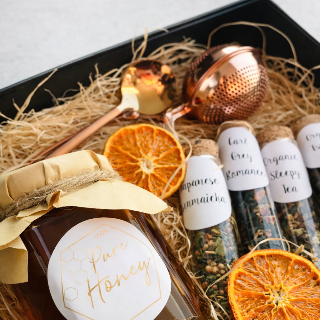 Gift set with honey, tea, and decorative items on a white background