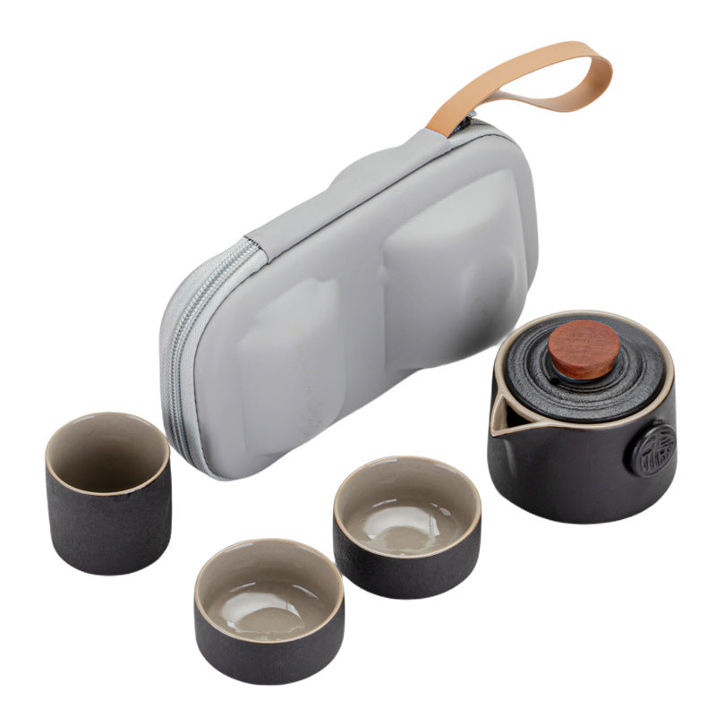Tea set with four cups and a black teapot on a white background