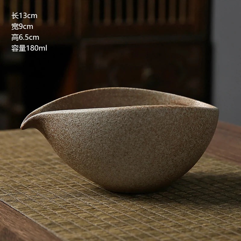 Brown ceramic teapot on a textured surface with dimensions displayed.