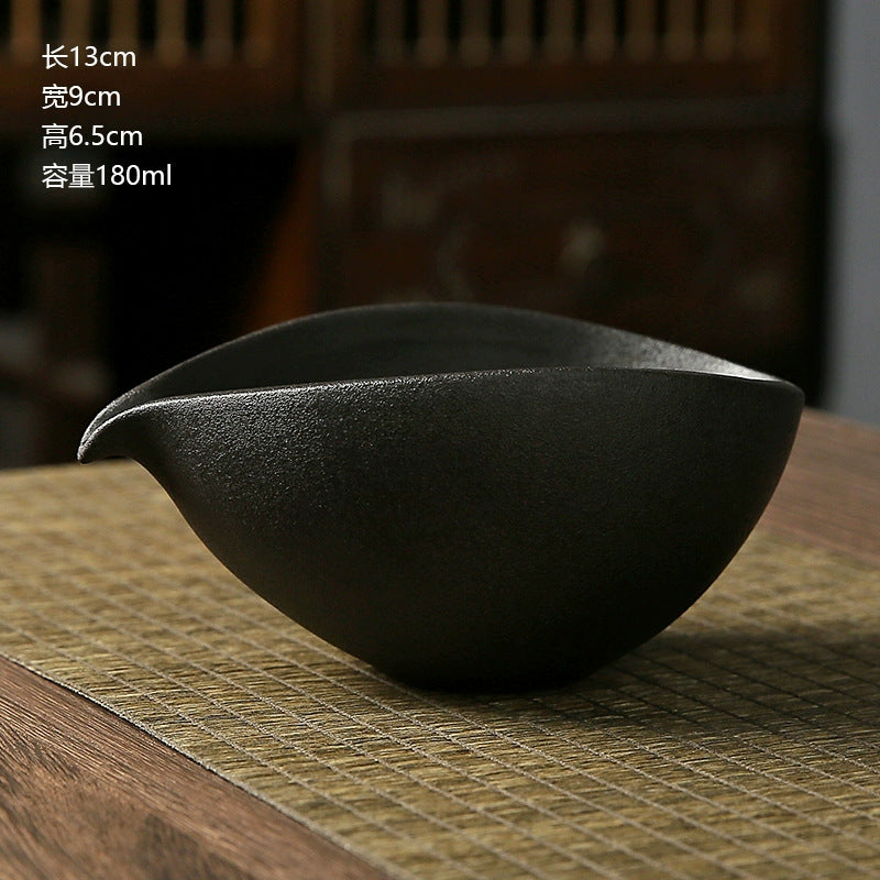 Black ceramic teapot on a wooden surface with text indicating dimensions and capacity.